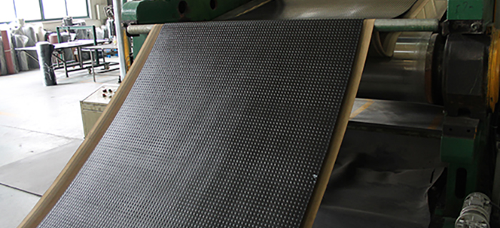 Black rubber matting being produced on machine - GCP Industrial Products