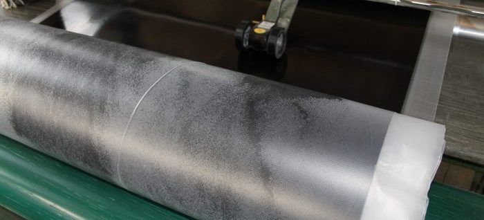 Black neoprene sheet rubber being produced on roto cure - GCP Industrial Products
