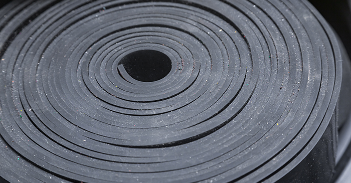 Industrial, new, black rubber twisted into a roll, close-up.